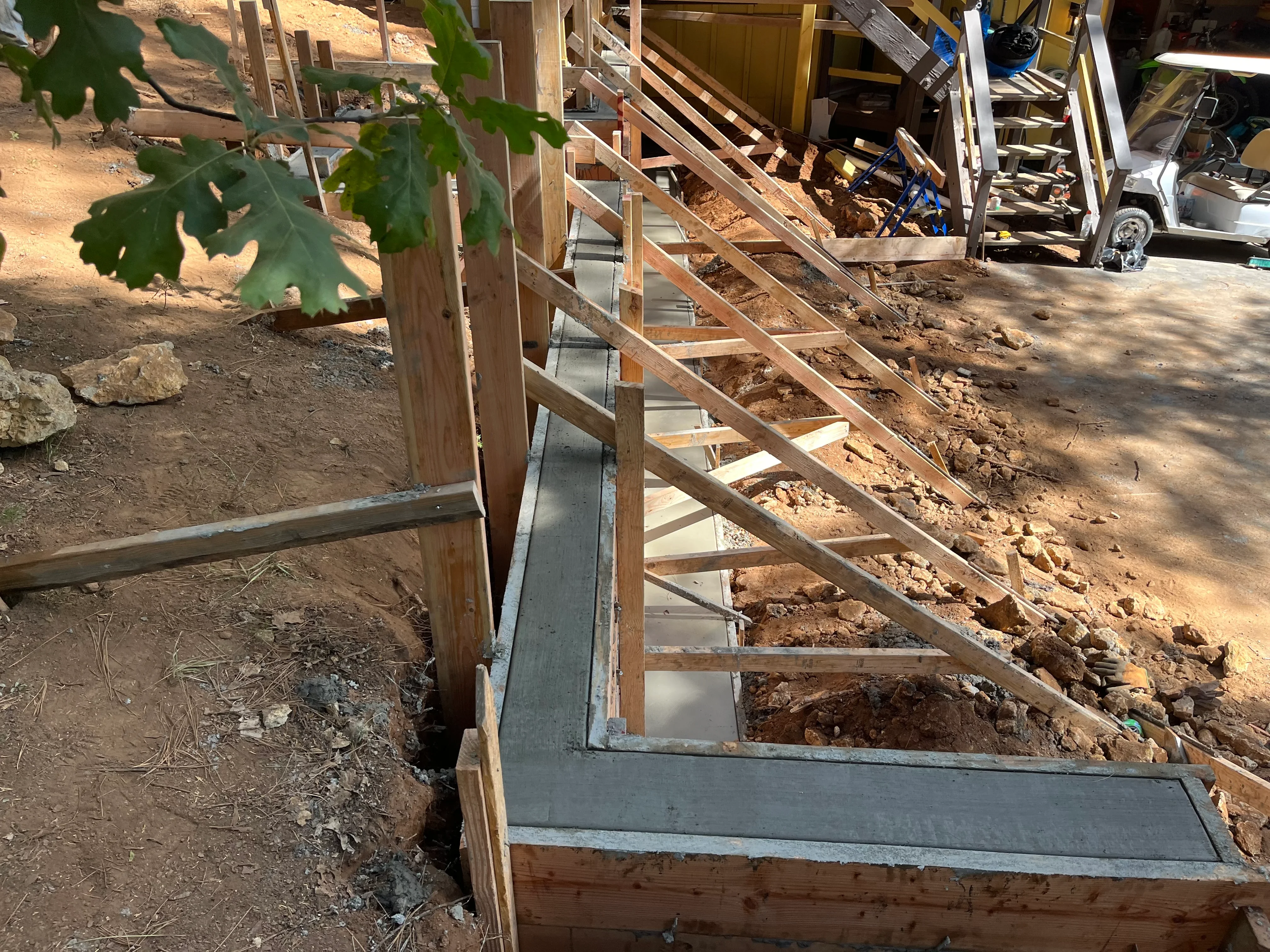 Pressure-treated wood framing with posts and beams on concrete foundation, sloped site