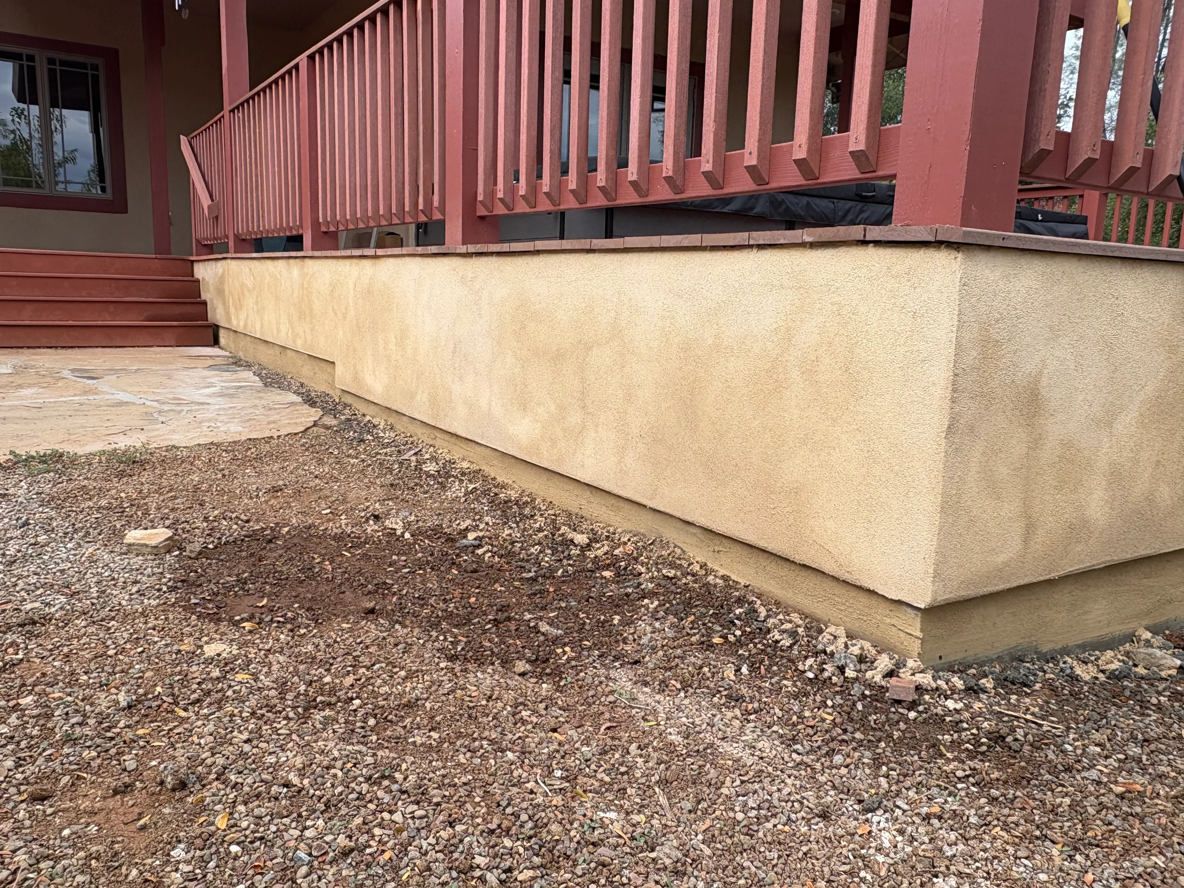Concrete retaining wall with stucco finish and gravel base drainage