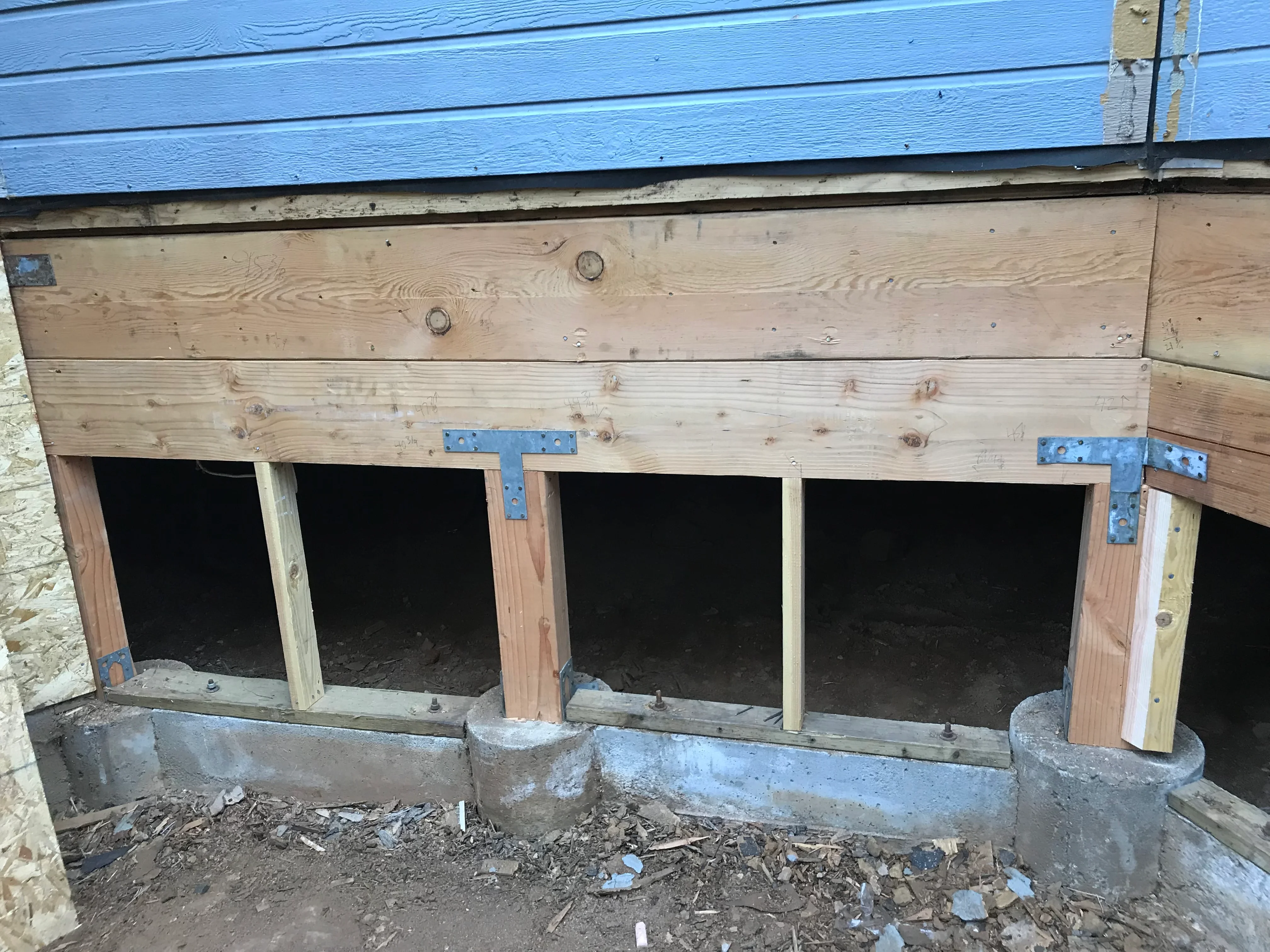 Wooden chicken coop with four nesting boxes, blue roof, and metal hinges
