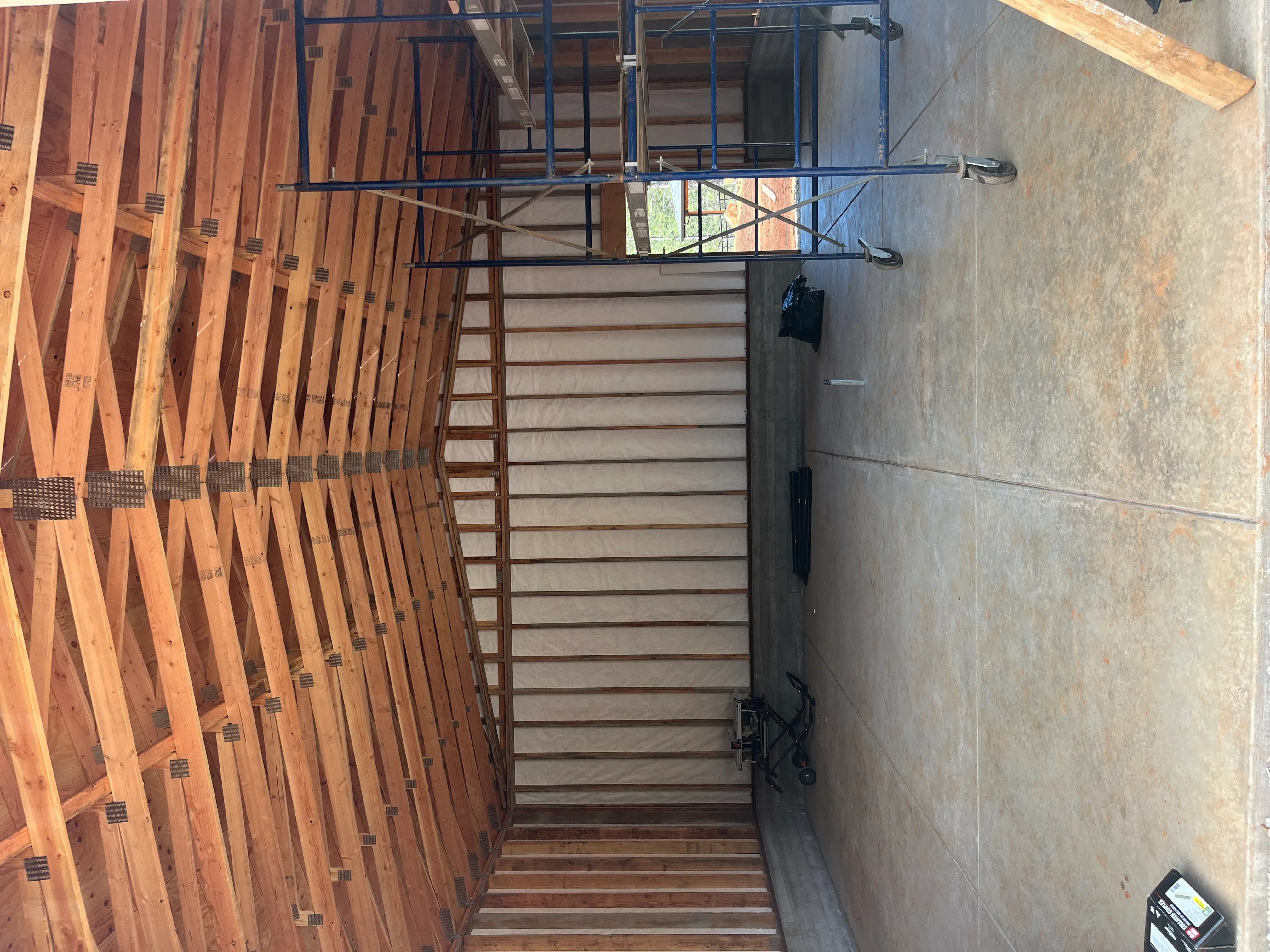 Wood framing with joists, metal bracing, and deck construction in progress