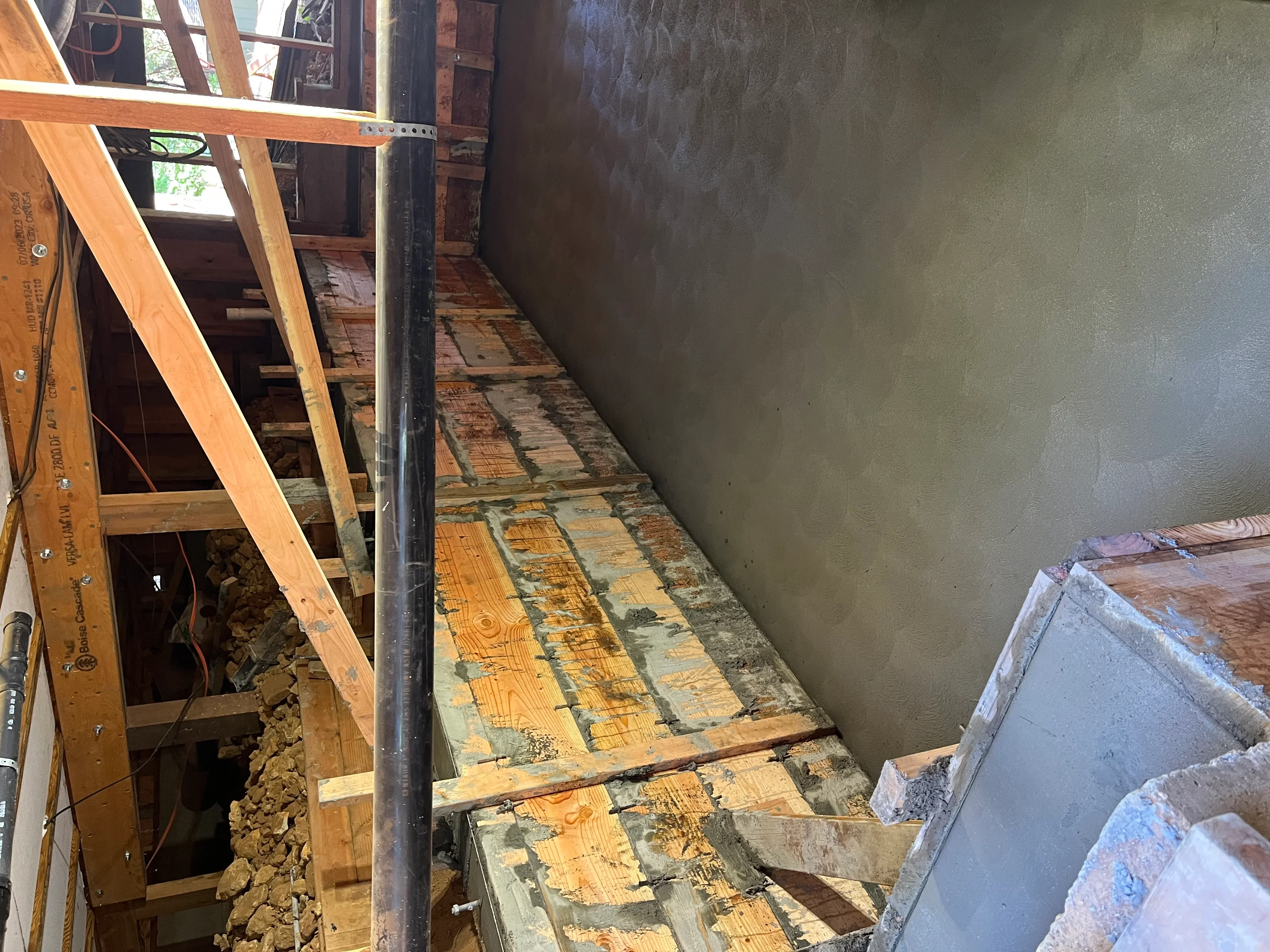 Interior wall framing with wooden studs, metal bracing, and drywall installation in progress