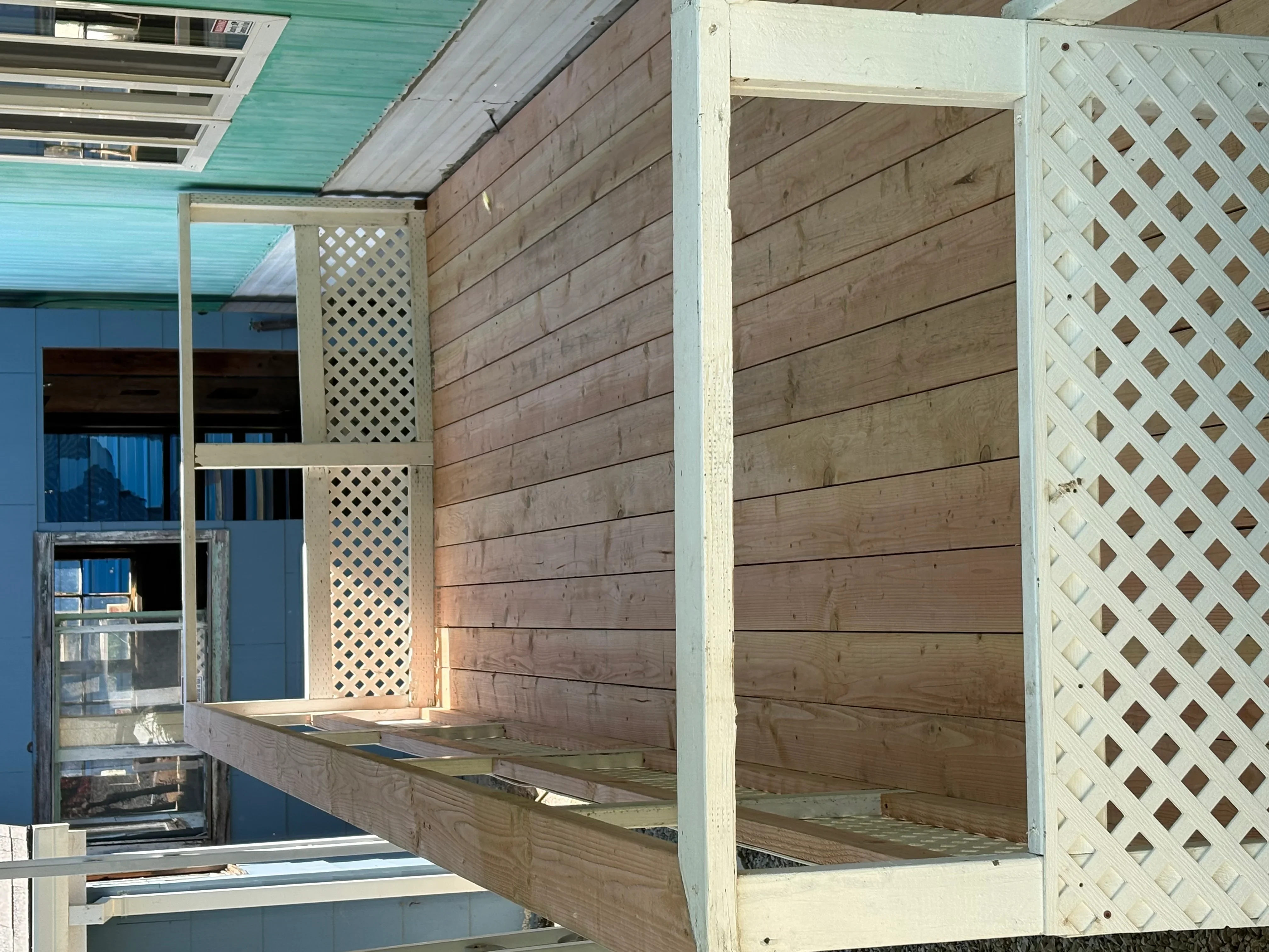 Wooden pergola with lattice privacy screens and horizontal beam construction on residential deck