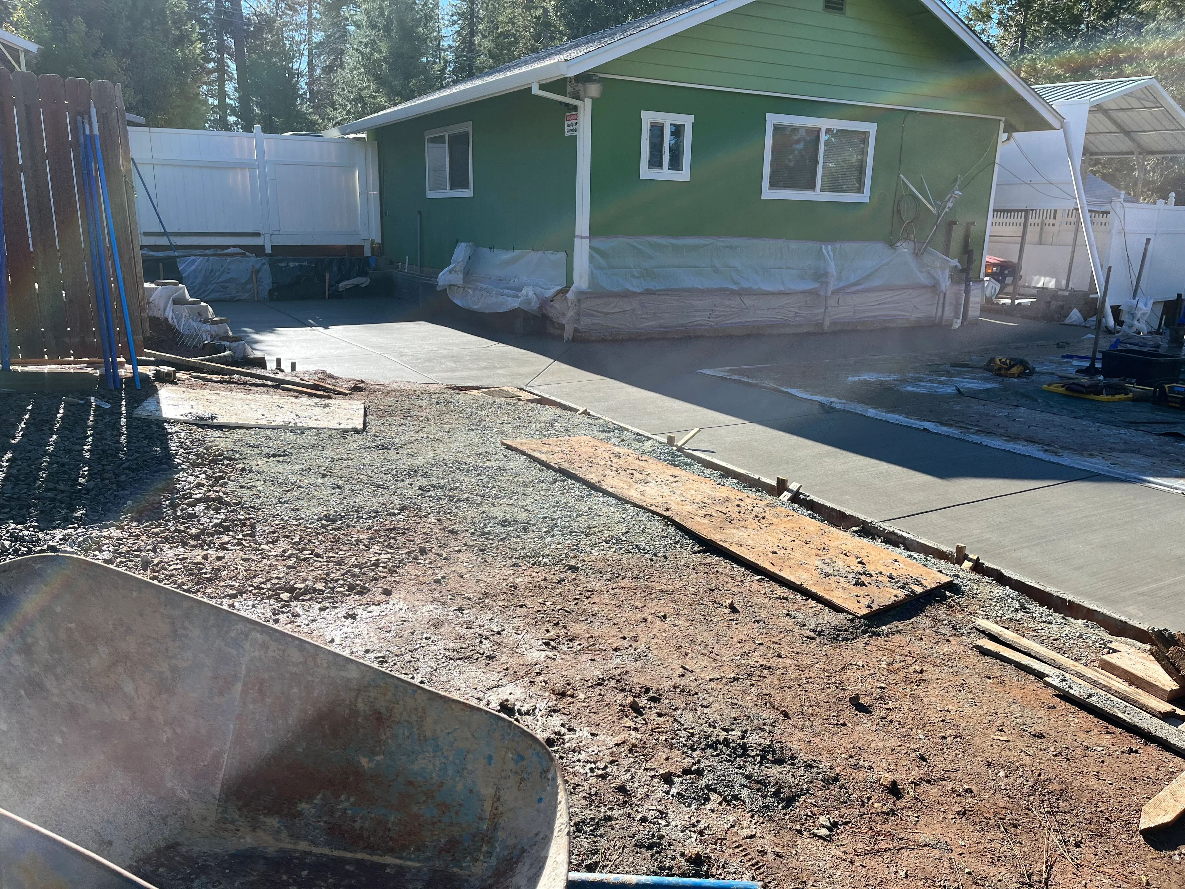 Concrete driveway installation with gravel base and wooden forms at residential home