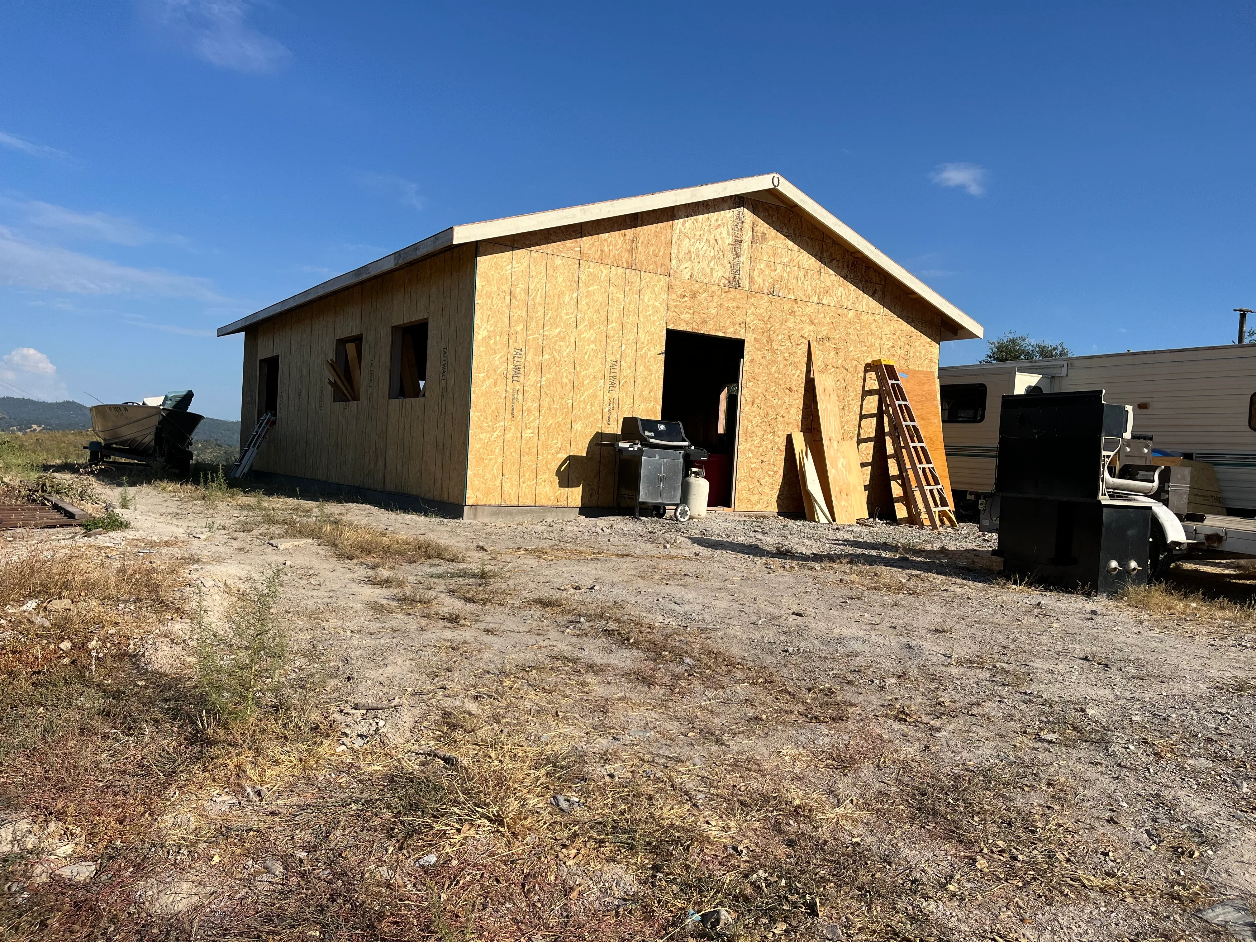 New wood-framed house with OSB sheathing, roof framing, and window openings under construction