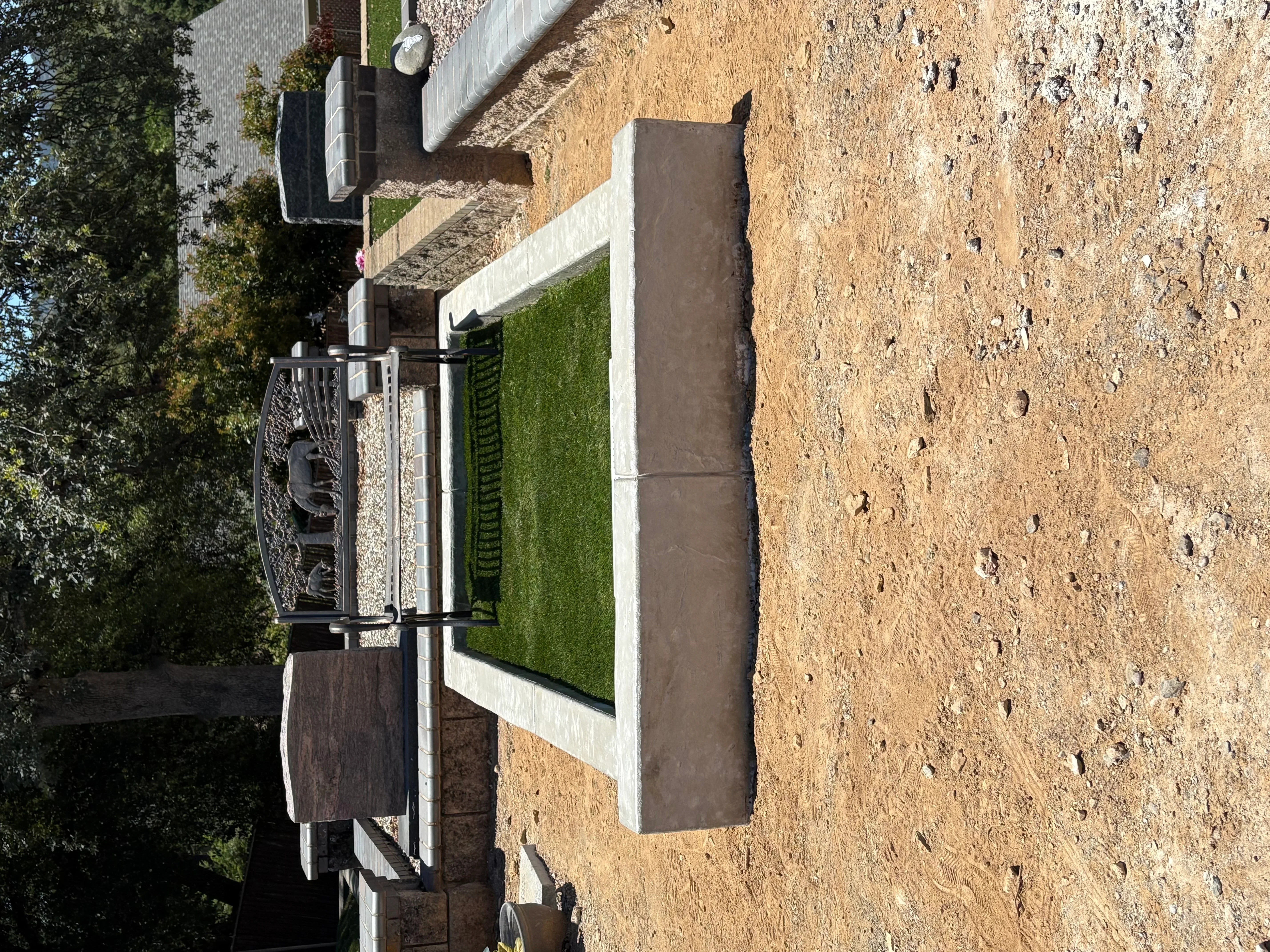 Asphalt driveway with concrete edging, gravel base, and newly installed sod landscape bed