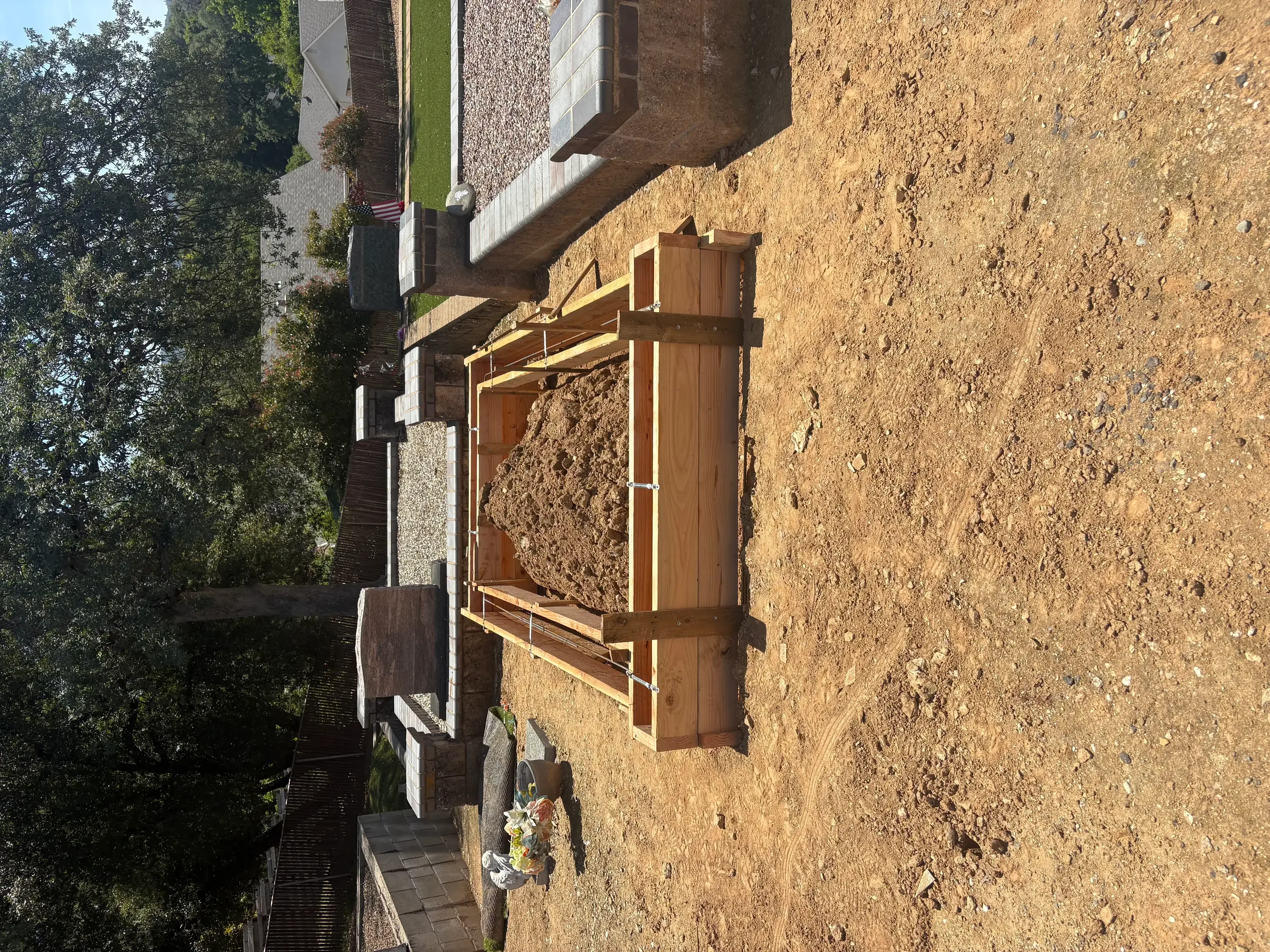 Wood deck with yellow metal railings and brown pressure-treated posts on sloped terrain